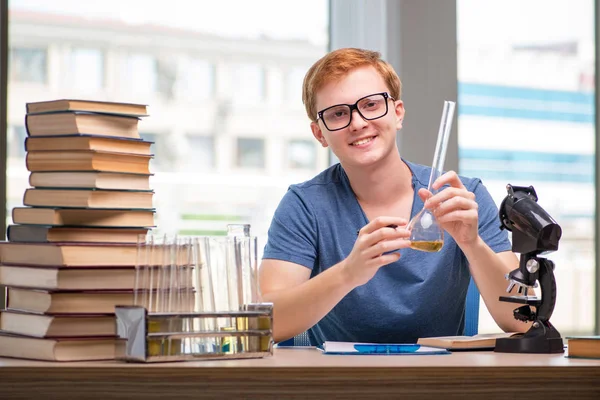 Jovem estudante cansado e exausto se preparando para o exame de química — Fotografia de Stock