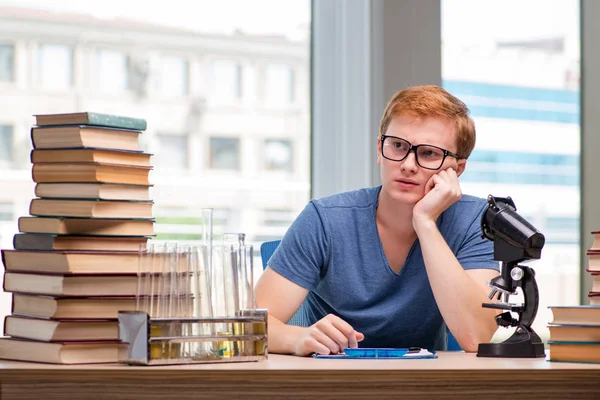 Jovem estudante cansado e exausto se preparando para o exame de química — Fotografia de Stock