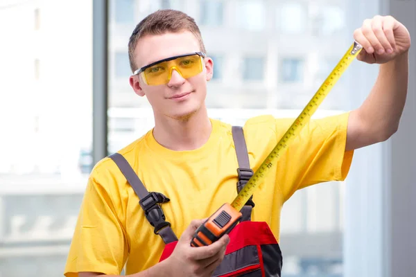 Jovem trabalhador da construção em macacões amarelos — Fotografia de Stock