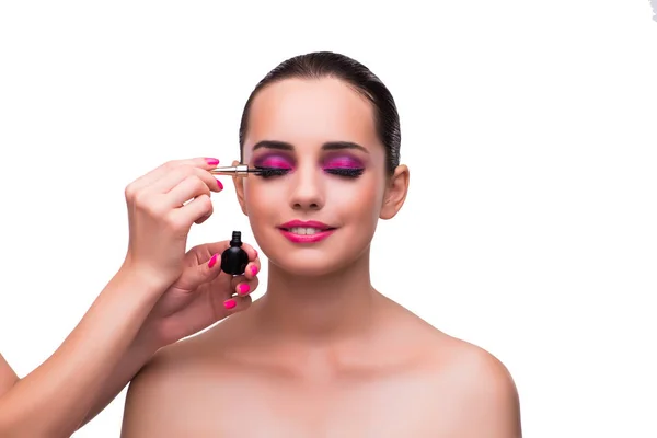 Vrouw krijgt make-up geïsoleerd op wit — Stockfoto