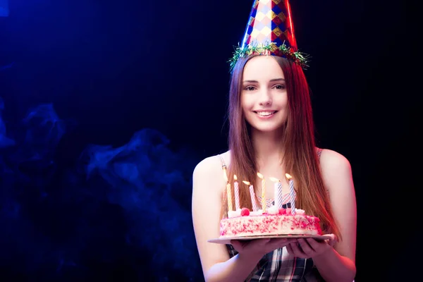 Młoda kobieta z tort urodzinowy na imprezie — Zdjęcie stockowe