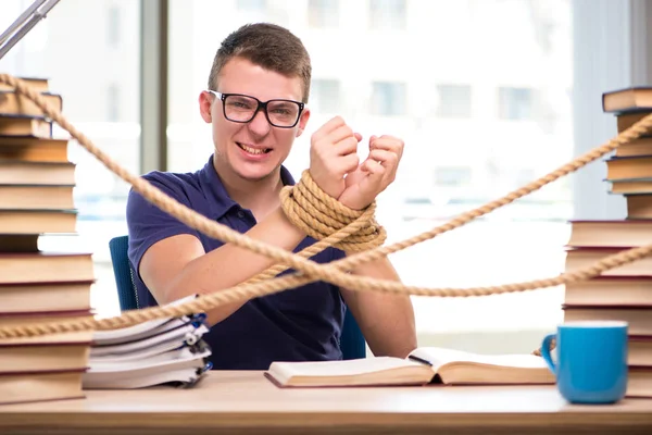 Jovem estudante forçado a estudar amarrado — Fotografia de Stock