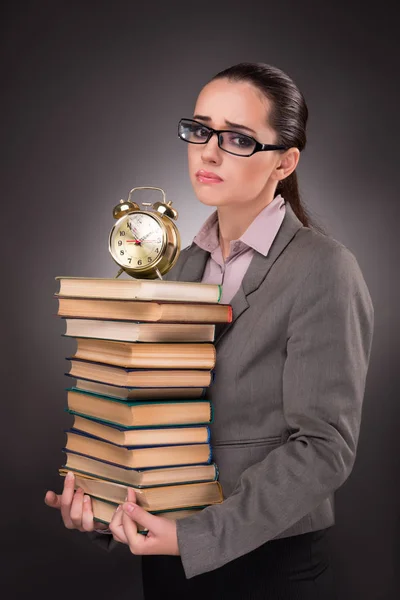 Young student with books and clock — Stock Photo, Image