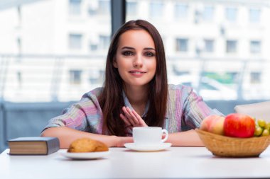 Genç kız sabah kahvaltı yapıyor.