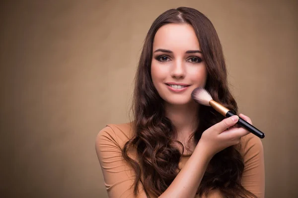 Hermosa mujer que aplica maquillaje en concepto de belleza — Foto de Stock