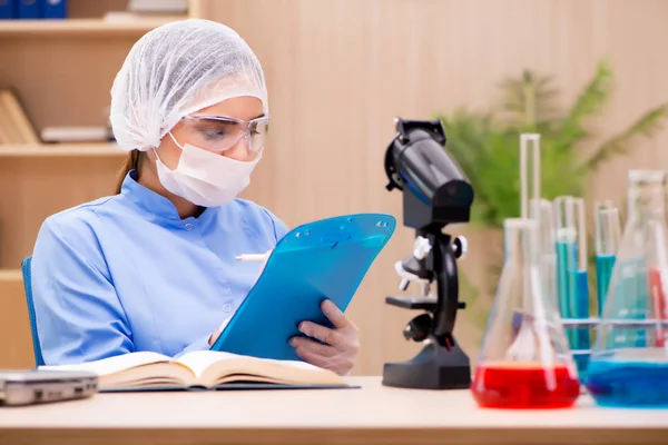 Químico de laboratorio que trabaja con microscopio y tubos — Foto de Stock