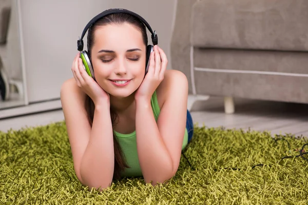 Jonge vrouw die thuis naar muziek luistert — Stockfoto