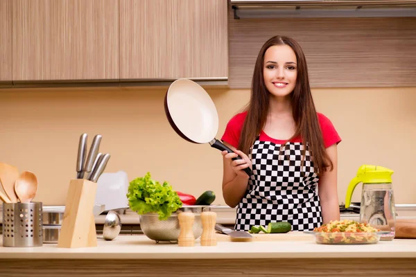 Young woman housewife working in the kitchen — Stock Photo, Image