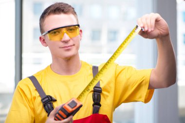 Sarı tulumlu genç inşaat işçisi.