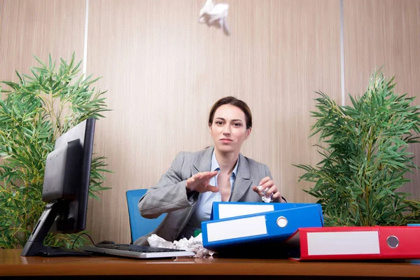 Женщина в состоянии стресса выбрасывает бумаги в офис — стоковое фото