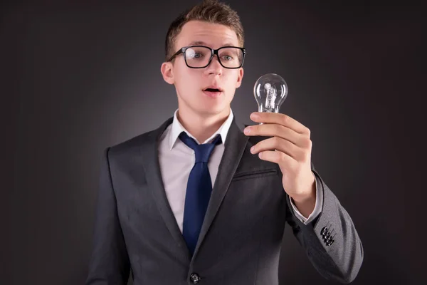 Young businessman with light bulb in idea concept — Stock Photo, Image