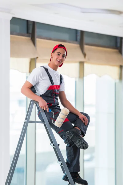 Jovem pintor pintando o teto no conceito de construção — Fotografia de Stock