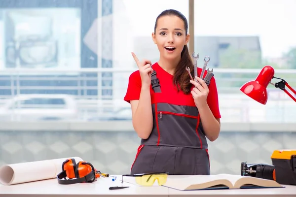 Mujer joven en mono haciendo reparaciones —  Fotos de Stock