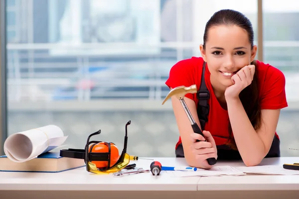 Young woman in coveralls doing repairs — Stock Photo, Image