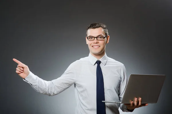 Joven hombre de negocios con portátil en concepto de negocio — Foto de Stock