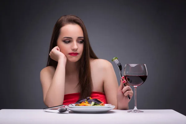 Hermosa mujer comiendo sola con vino — Foto de Stock