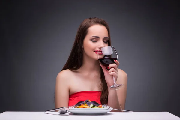 Hermosa mujer comiendo sola con vino — Foto de Stock