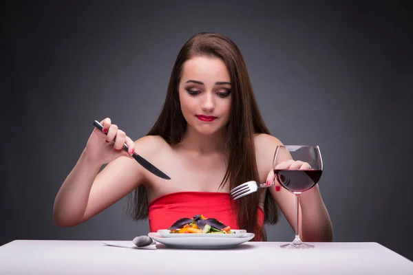 Hermosa mujer comiendo sola con vino — Foto de Stock