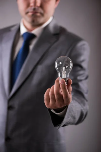 Businessman holding light bulb in creativity concept — Stock Photo, Image