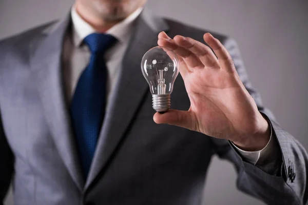 Affärsman som håller glödlampan i kreativitet koncept — Stockfoto