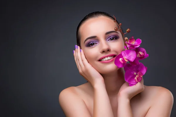 Young beautiful woman with orchid flower — Stock Photo, Image