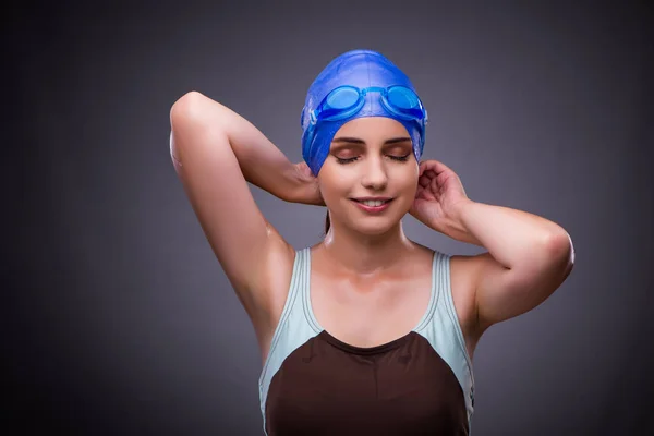 Vrouw zwemmer tegen de grijze achtergrond — Stockfoto