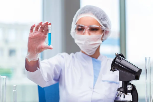 Estudiante joven trabajando con soluciones químicas en laboratorio — Foto de Stock