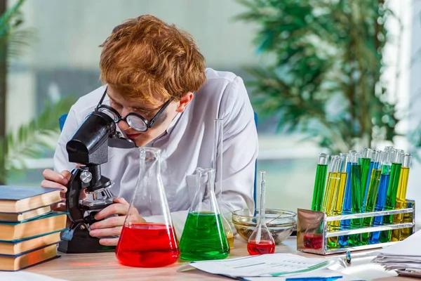Młody szalony chemik pracuje w laboratorium — Zdjęcie stockowe
