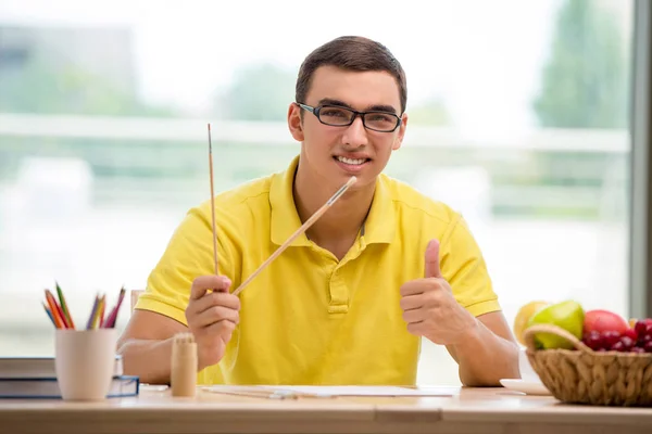 Young man drawing pictures in studio — Stock Photo, Image