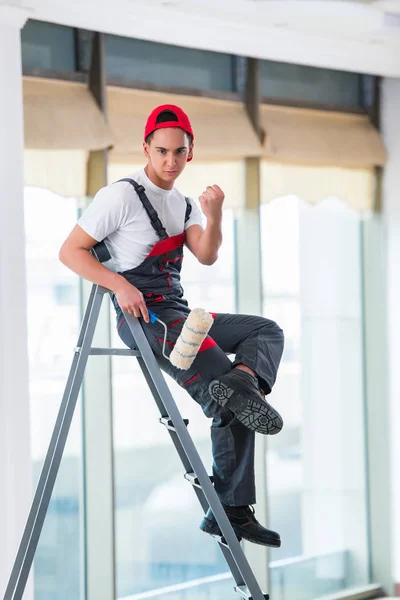 Jovem pintor pintando o teto no conceito de construção — Fotografia de Stock