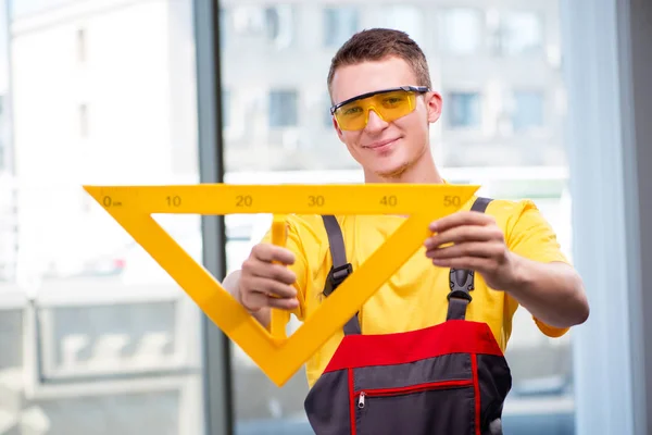 Młody pracownik budowlany w żółtych kombinezonach — Zdjęcie stockowe