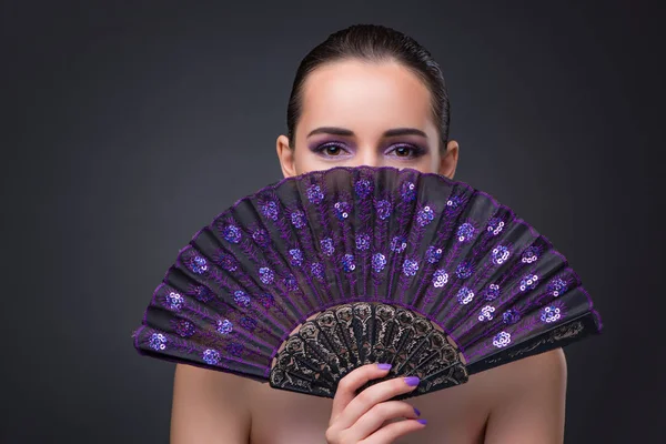 Mujer agradable con ventilador sobre fondo gris —  Fotos de Stock