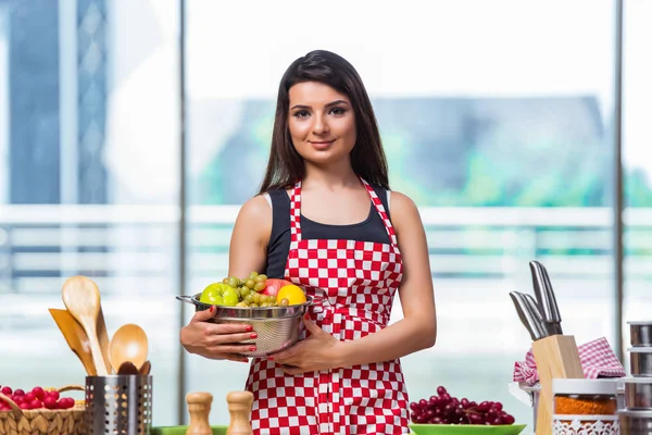 Cocinero joven con frutas en la cocina — Foto de Stock