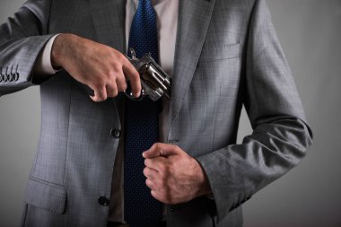 Adam cebinden silahını çekerek