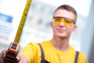 Sarı tulumlu genç inşaat işçisi.