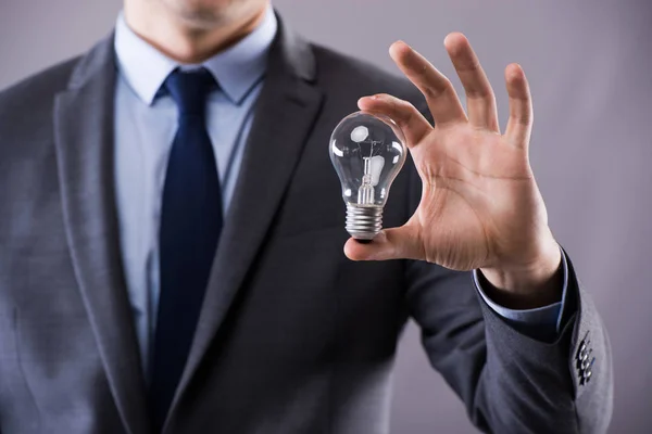 Бизнесмен держит лампочку в творческой концепции — стоковое фото