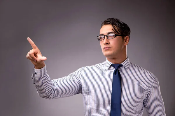 Junger gutaussehender Geschäftsmann drückt Knöpfe auf grauem Hintergrund — Stockfoto