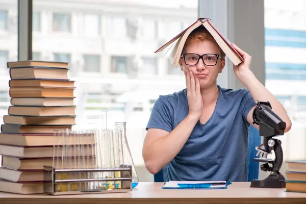 Giovane studente stanco ed esausto preparazione per l'esame di chimica — Foto Stock