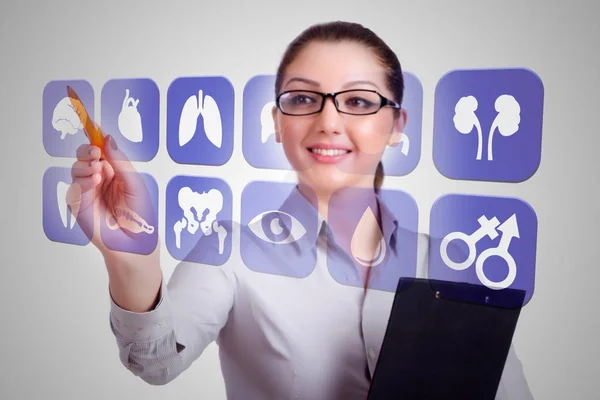 Vrouwelijke arts drukt op knoppen met verschillende medische iconen — Stockfoto