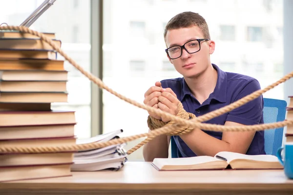 Jovem estudante forçado a estudar amarrado — Fotografia de Stock