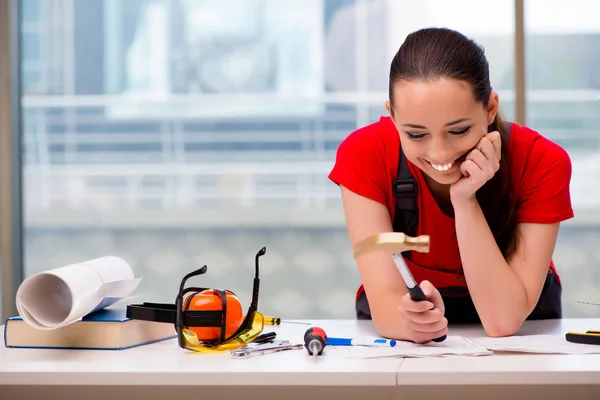 Mujer joven en mono haciendo reparaciones — Foto de Stock