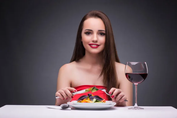 Красивая женщина ест одна с вином — стоковое фото