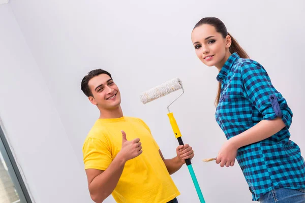 Young couple painting wall at home — Stock Photo, Image