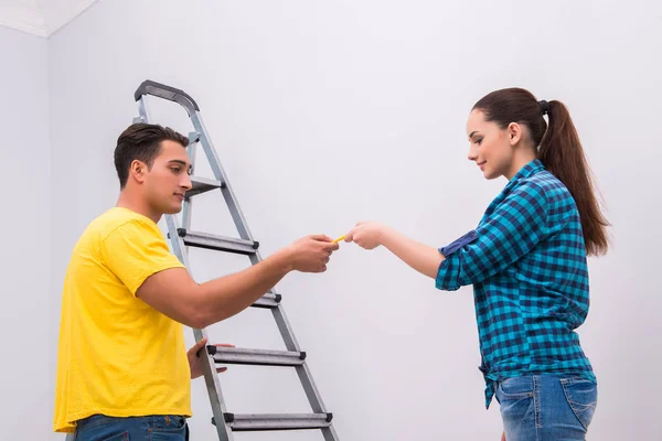 Jovem casal parede de pintura em casa — Fotografia de Stock