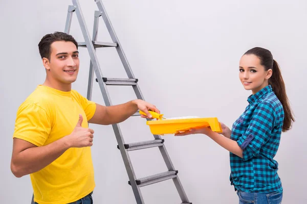 Jovem casal parede de pintura em casa — Fotografia de Stock