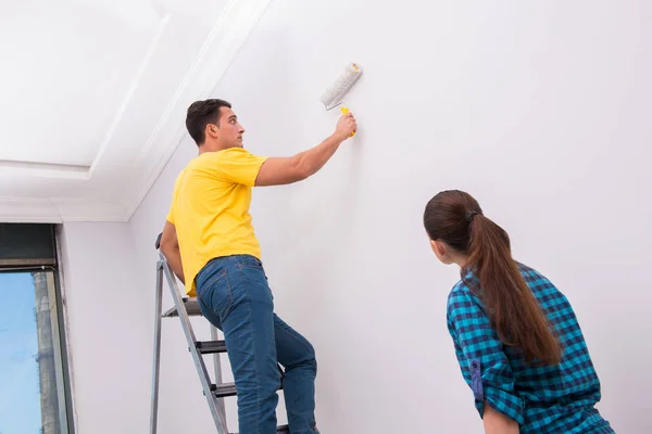 Young couple painting wall at home — Stock Photo, Image