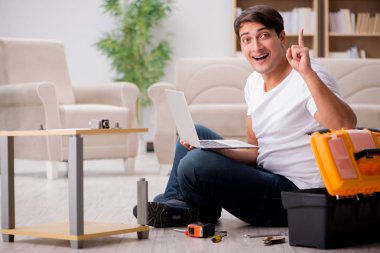 Evdeki rafları monte eden adam