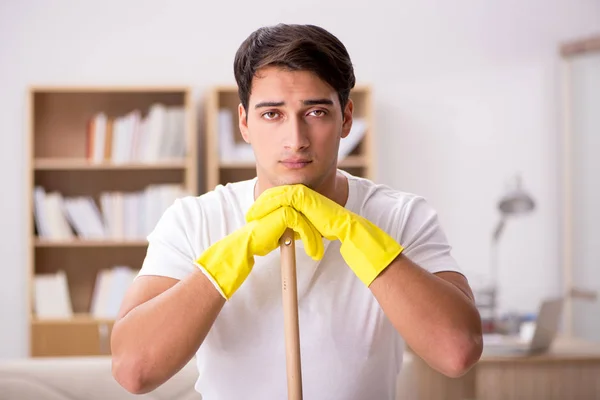 Άντρας σύζυγος καθαρίζει το σπίτι στην έννοια της οικογένειας — Φωτογραφία Αρχείου