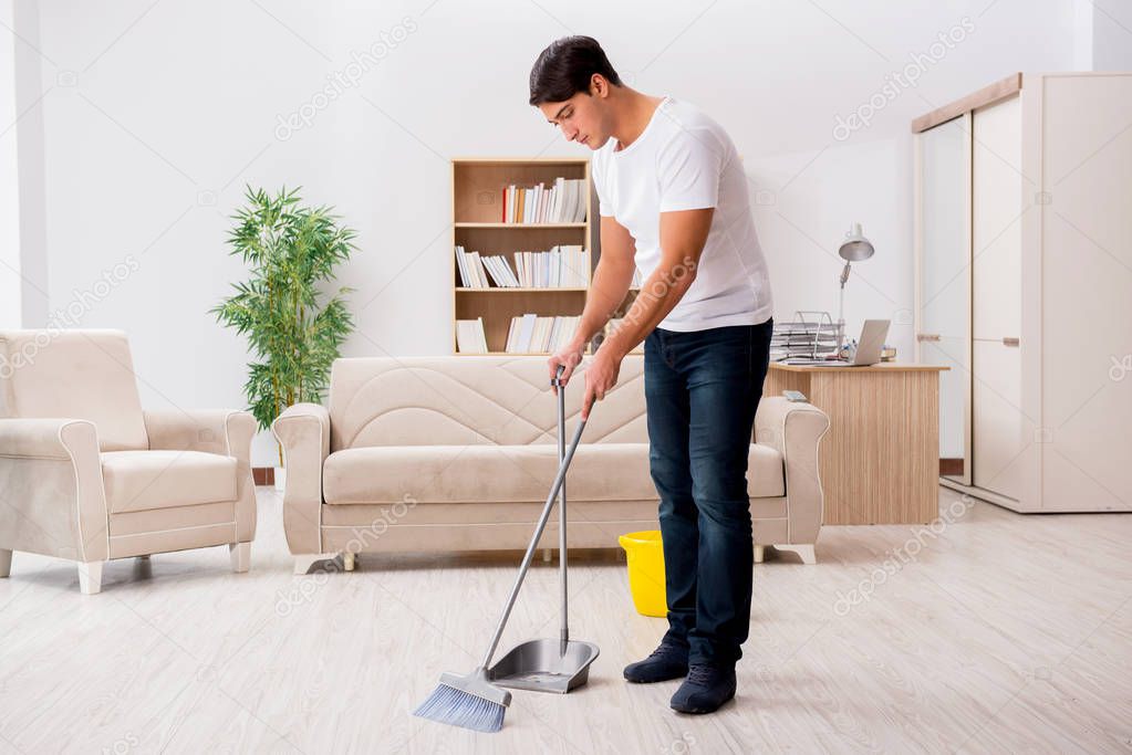 Man cleaning home with broom