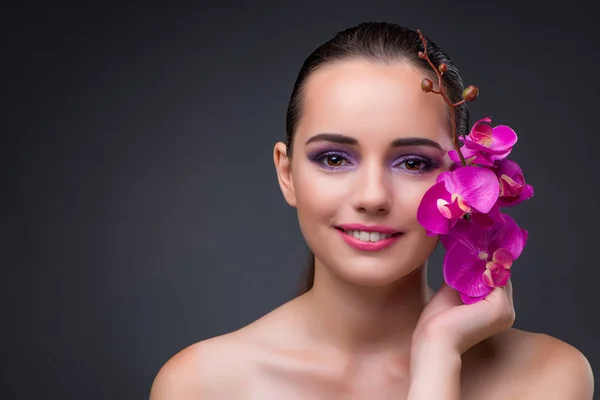 Ung vacker kvinna med orkidé blomma — Stockfoto